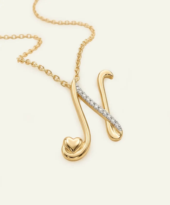 Gold necklace with a unique pendant on a light beige background
