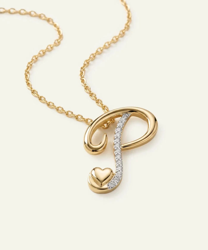 Gold necklace with a heart and infinity symbol pendant on a light beige background