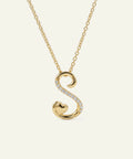 Gold necklace with a 'S' shaped pendant on a white background