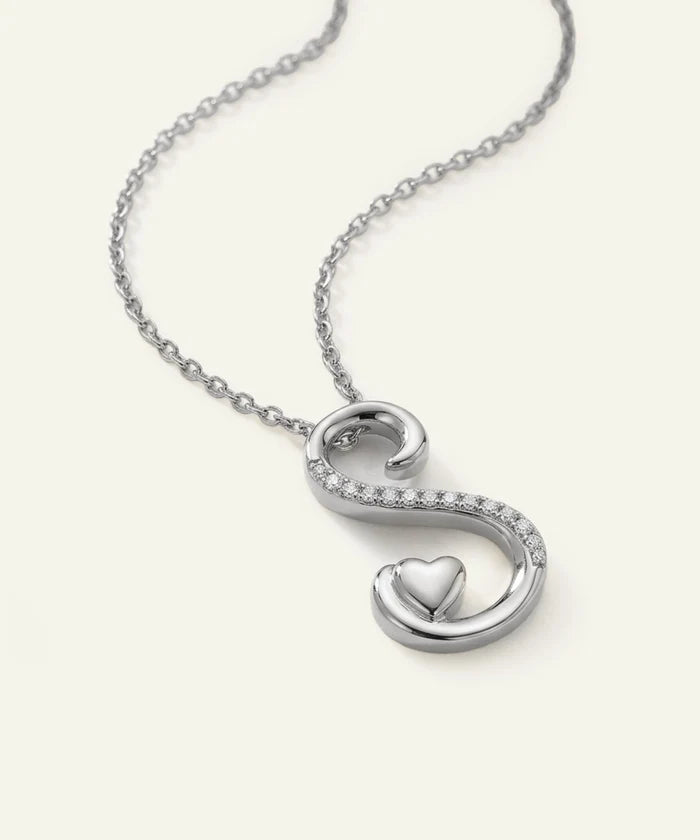 Silver necklace with a heart-shaped pendant on a white background