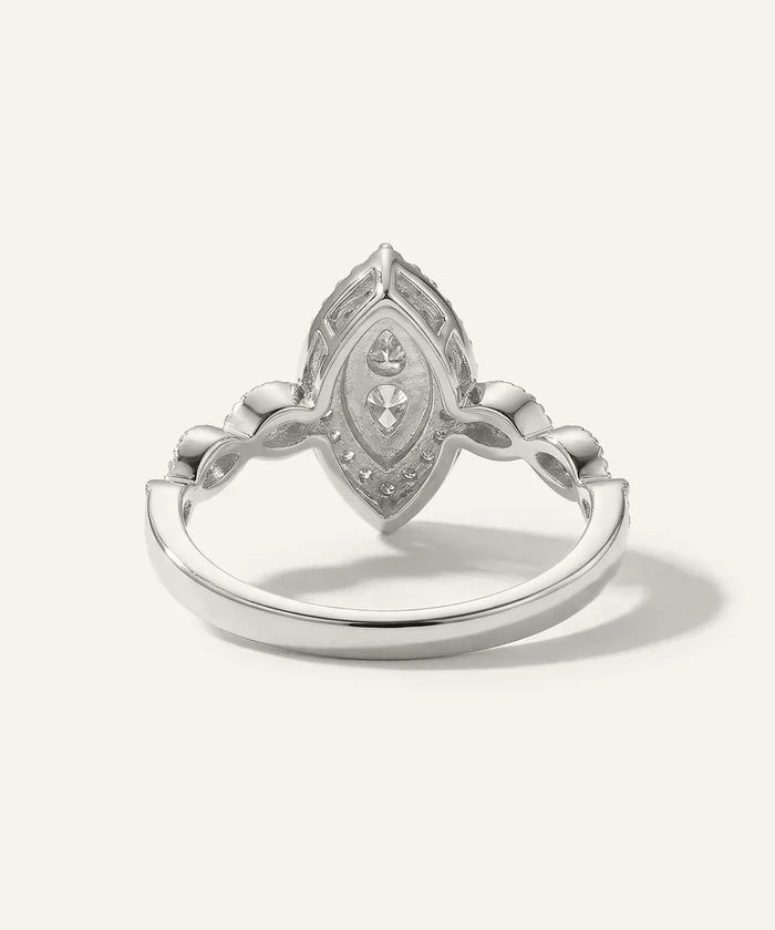 Silver ring with intricate design on a white background