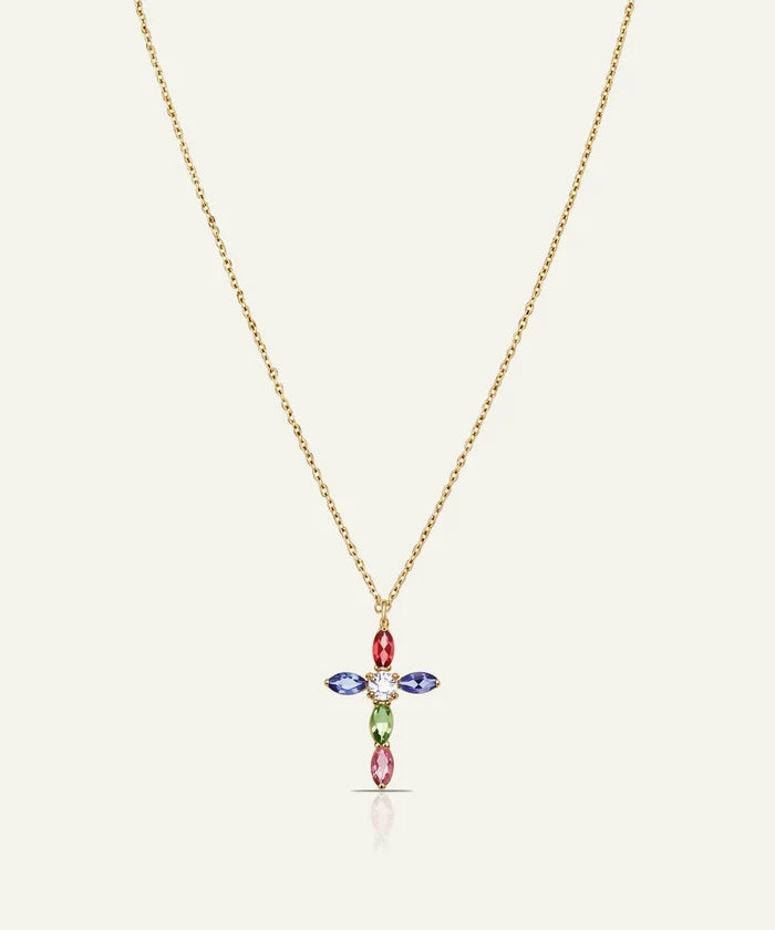 A delicate gold chain necklace featuring a cross-shaped pendant adorned with colorful marquise-cut gemstones in red, blue, green, and pink, set against a light cream background.