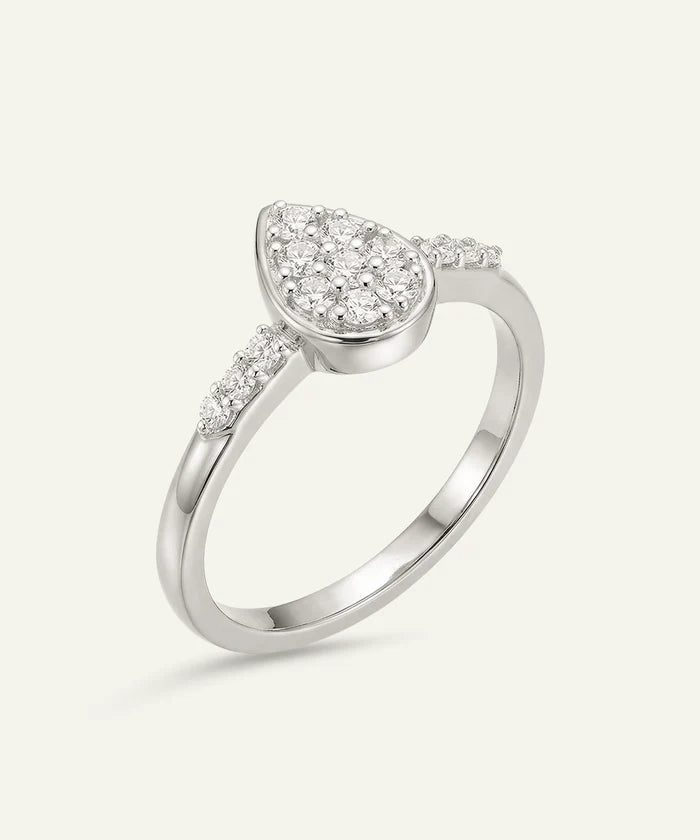 Silver ring with a pear-shaped diamond center on a white background