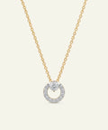 Gold necklace with a diamond pendant on a light beige background