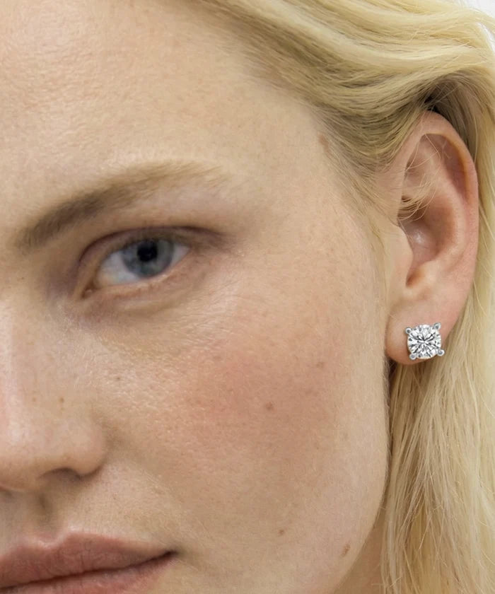 Close-up of a woman wearing a diamond earring.