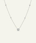 Delicate silver necklace with small round pendants on a light gray background