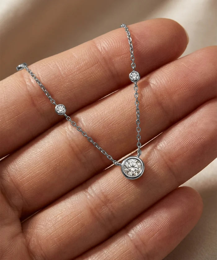 Silver bracelet with diamond accents on a hand against a neutral background