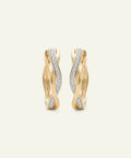 Gold hoop earrings with diamond accents on a light beige background