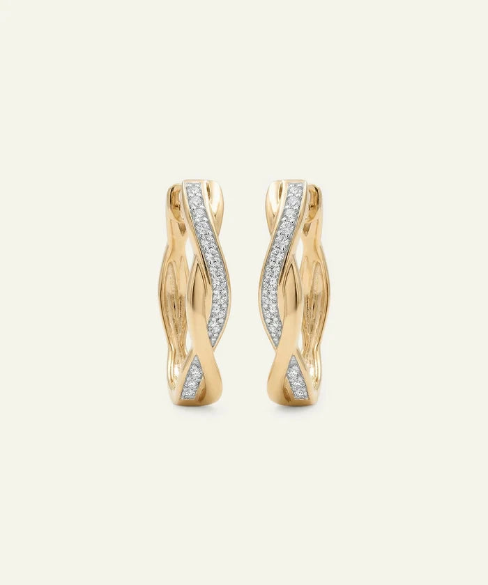 Gold hoop earrings with diamond accents on a light beige background