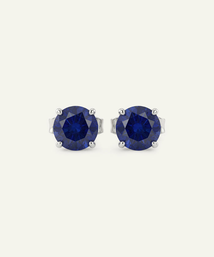 Pair of blue gemstone stud earrings on a white background