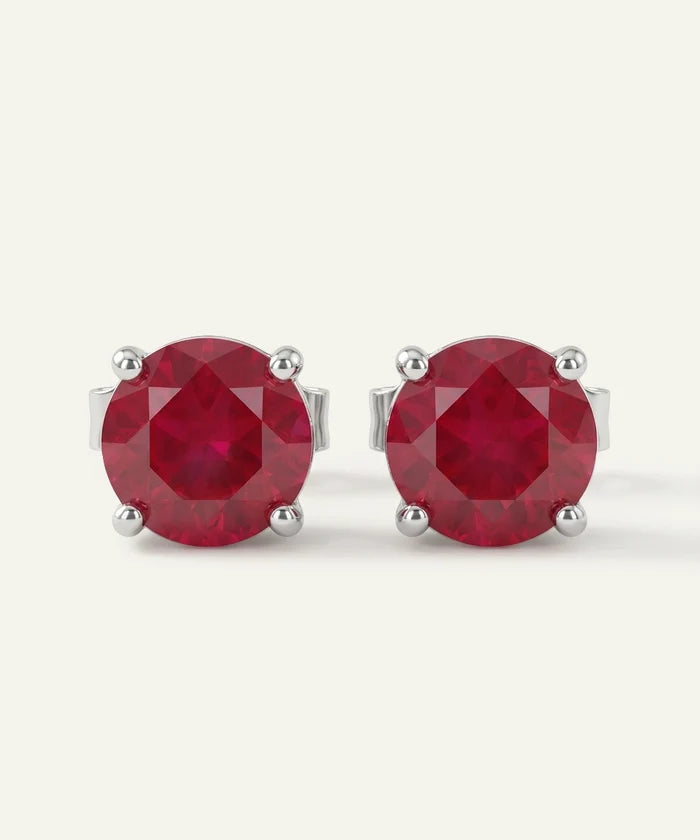 Pair of red gemstone stud earrings on a white background