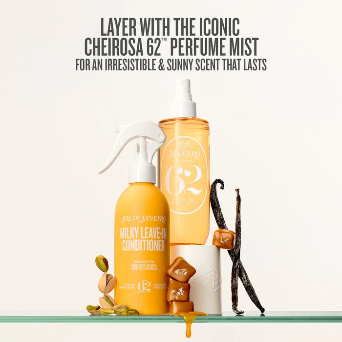 Two orange bottles with white sprayers on a glass shelf, vanilla beans, and nuts.