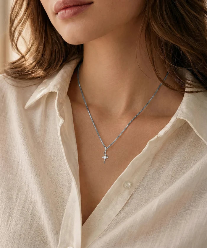 Necklace with a star pendant worn by a person in a light-colored shirt.