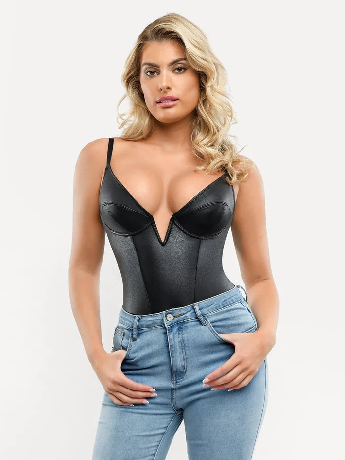 Black faux leather plunging V sculpting corset bodysuit paired with blue jeans.