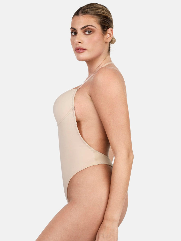 Beige shapewear bodysuit with deep U plunge, halter straps, and backless design for sculpting.