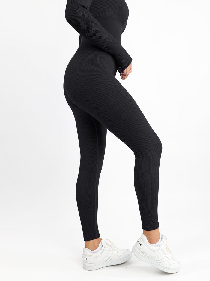 Black ribbed seamless long sleeve shapewear jumpsuit with thumb holes and square neck.
