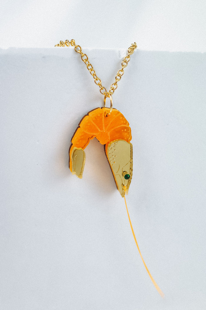 A whimsical gold Shrimp Pendant Necklace featuring a realistic orange and beige shrimp, displayed against a plain white background for a playful touch.