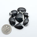 White Buffalo stone cabochons, white stone with black matrix, polished stones on a white background, with a US dime for scale